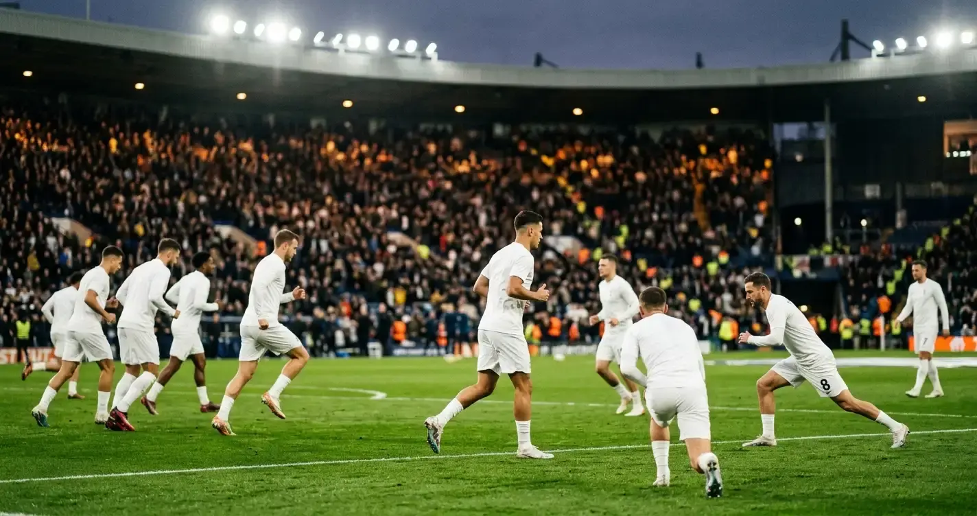 An England-style football team warming up under stadium floodlights before a match