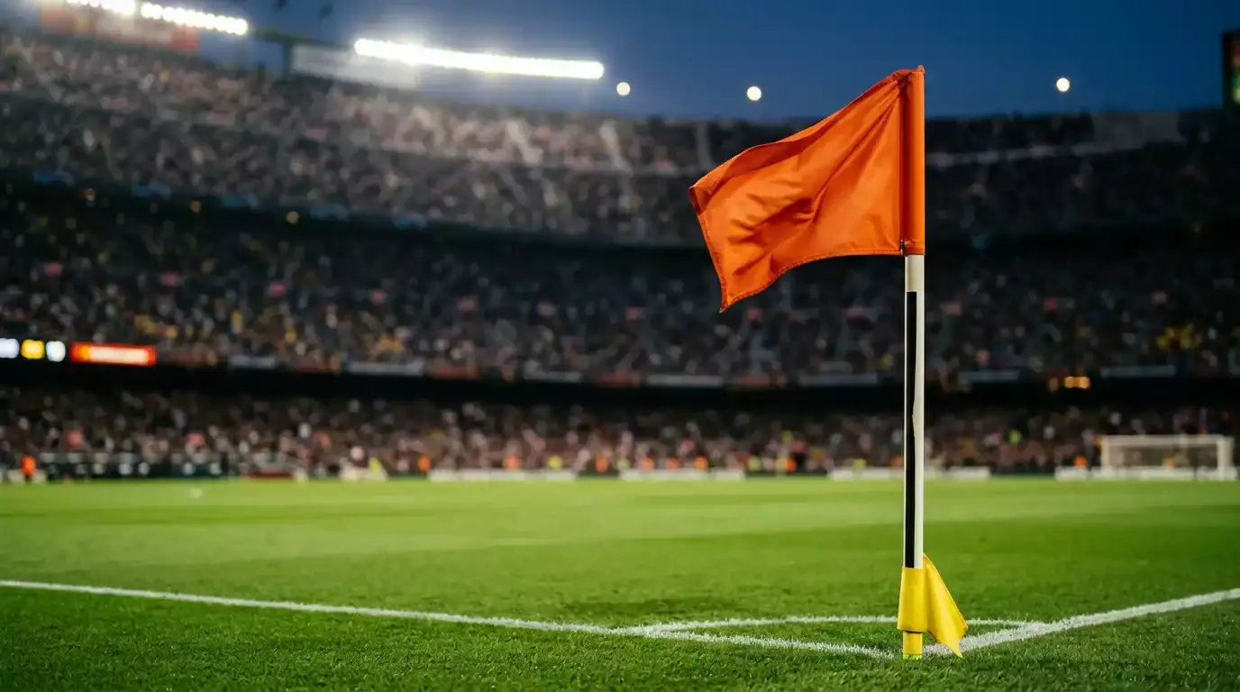 A close-up of a corner flag against a blurred backdrop of stadium stands