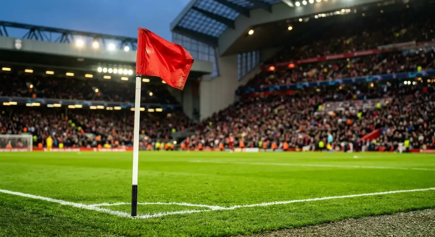 A close-up of a corner flag against a blurred backdrop of stadium stands under warm evening light