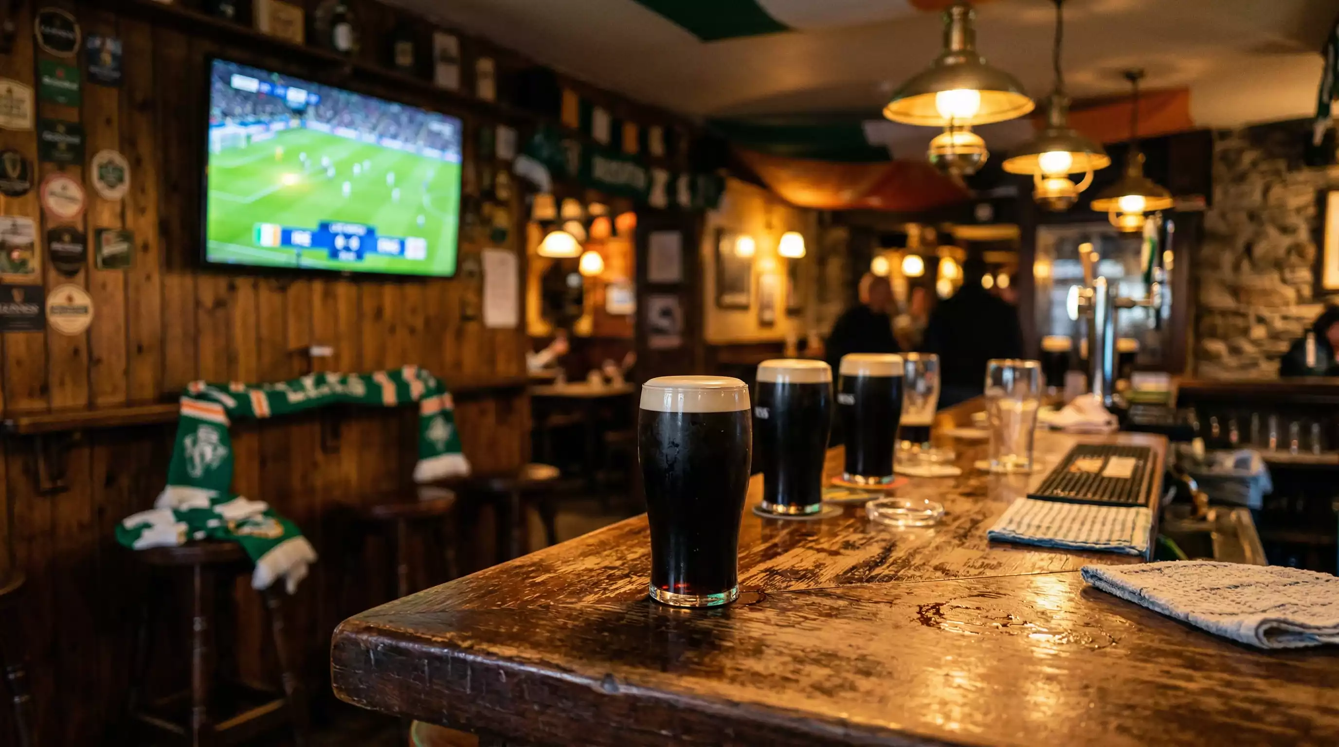 Irish football fans gathered in a packed pub watching a World Cup match on a big screen with green jerseys visible in the crowd